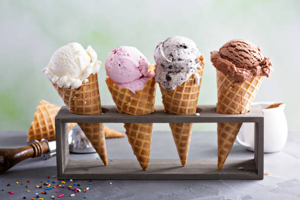Image of a variety of ice cream scoops in cones with chocolate, vanilla and strawberry
